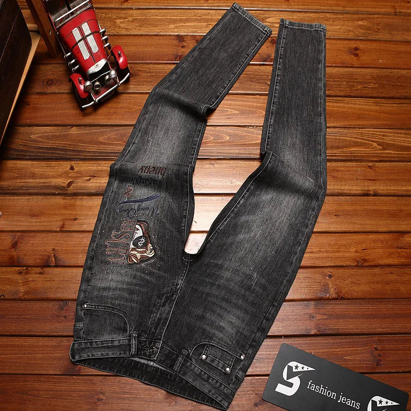 Black distressed jeans on a wooden surface with a brand card.