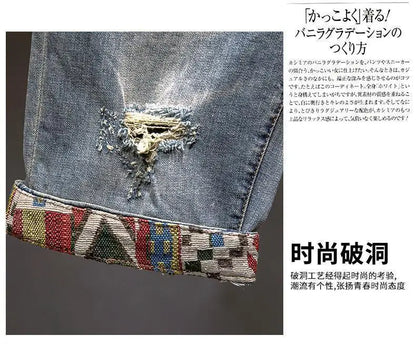 Close-up of a denim fabric with decorative stitching and beads on a gray background