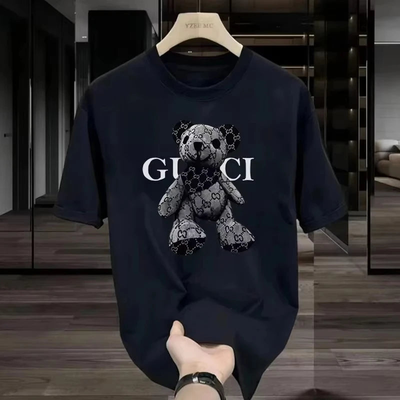 Navy blue Gucci t-shirt with teddy bear design on a hanger.