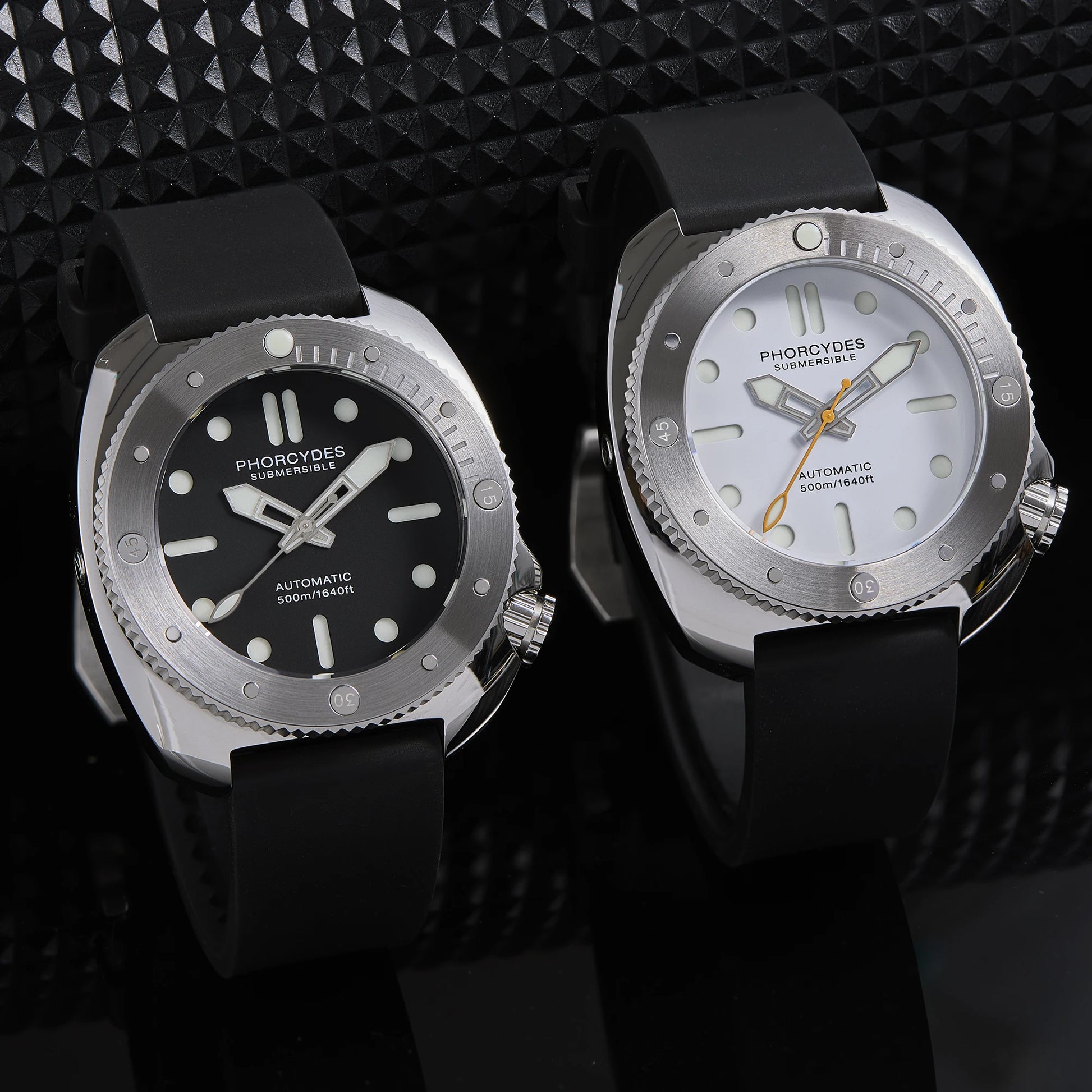 Two watches with black and silver designs on a textured black background