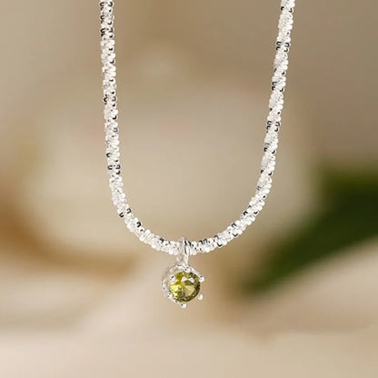 Necklace with a green gemstone pendant on a blurred background