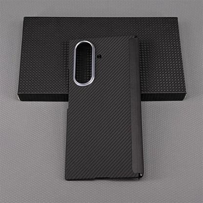 Black carbon fiber phone case on a gray background