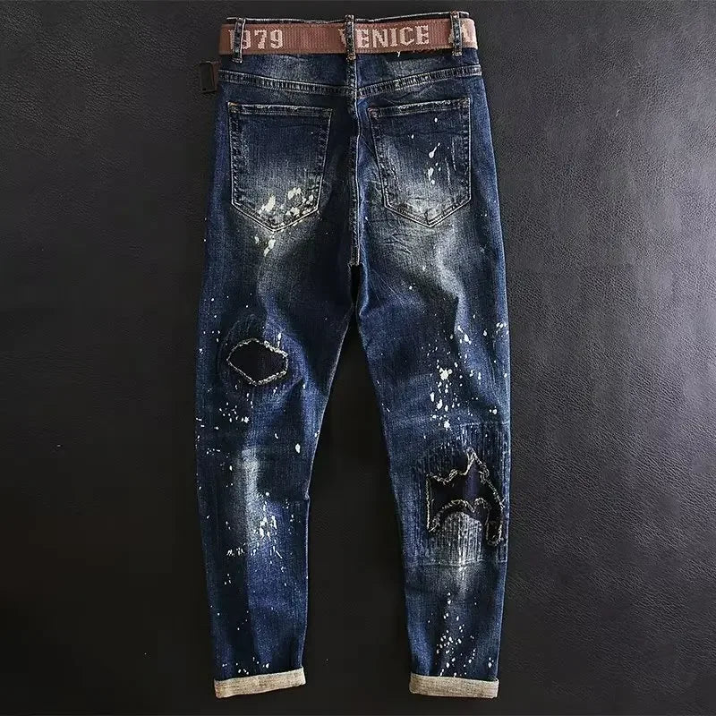 Distressed blue jeans with a brown belt on a dark background
