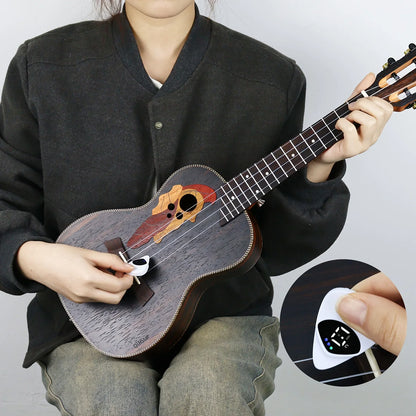 Person holding a ukulele with a close-up of a digital tuner on a gray background