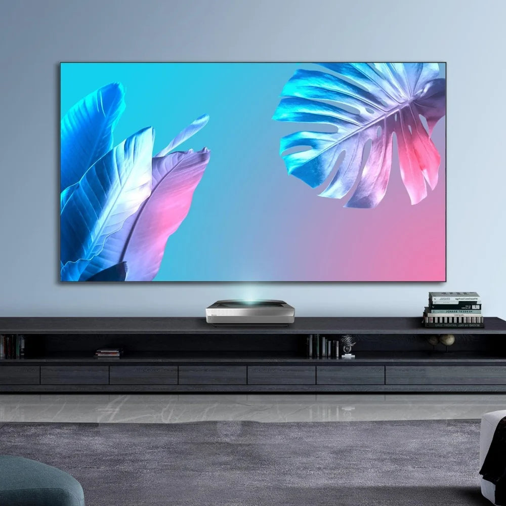 Modern living room with a large TV displaying colorful leaf graphics, a projector, and a sound system.