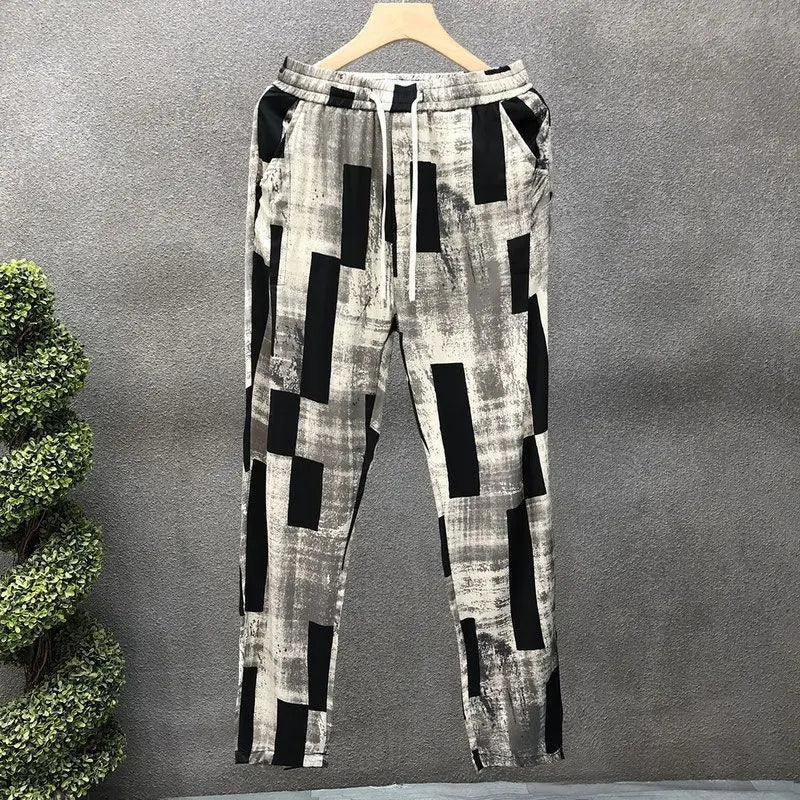 Plaid patterned pants on a hanger against a gray background