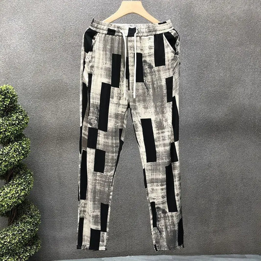 Plaid patterned pants on a hanger against a gray background