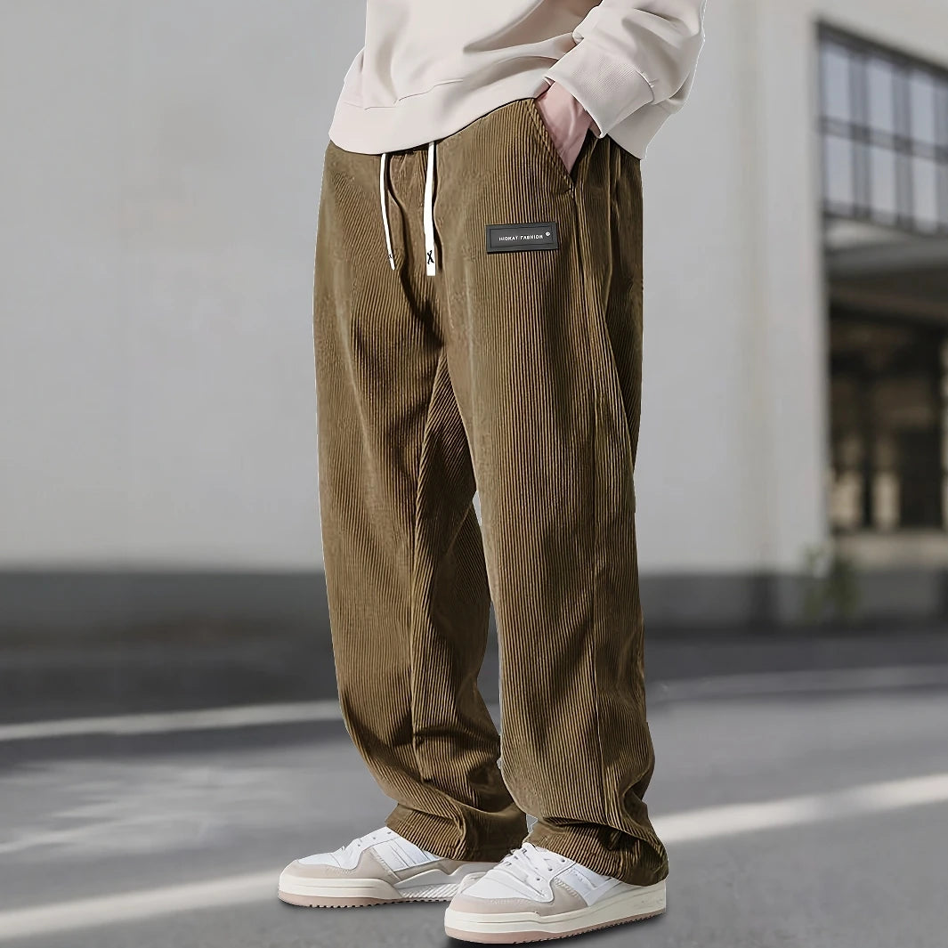 Person wearing brown corduroy pants with a blurred background