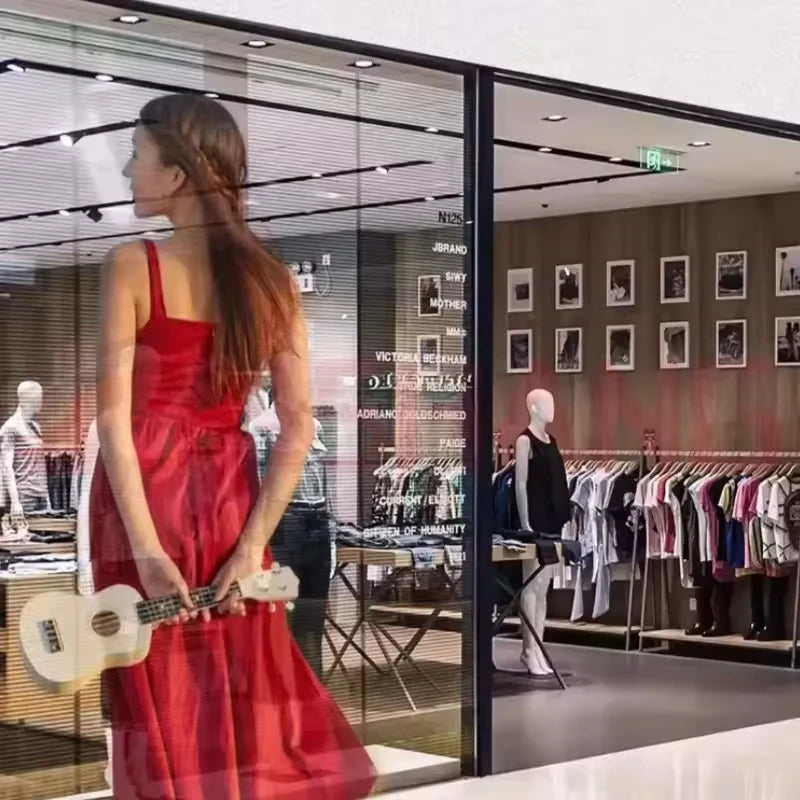 Woman in a red dress holding a white guitar in a clothing store.