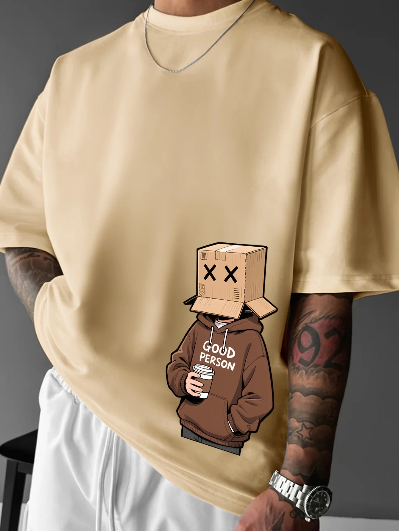 Beige sweatshirt with a graphic of a person wearing a brown hoodie labeled 'Good Person' and a cardboard box on their head.