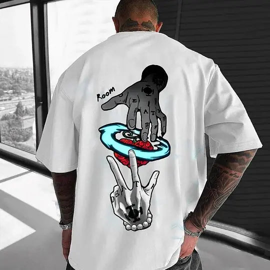 Person wearing a white t-shirt with graphic designs on the back, standing indoors.