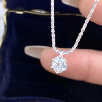 Diamond necklace held by a hand with a dark background