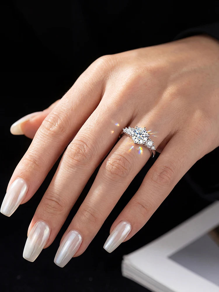 Hand wearing a diamond ring with a black background