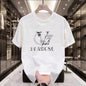 White t-shirt with black logo and text held in a modern interior setting