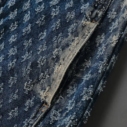 Close-up of blue denim fabric with subtle pattern on a dark background