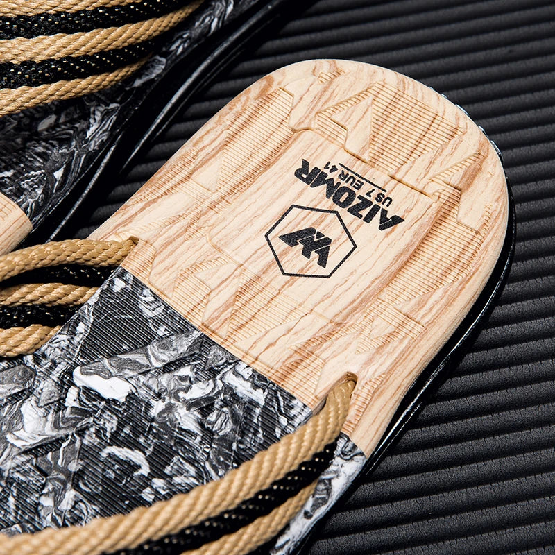 Close-up of a sandal with wooden sole and brand logo on a textured surface