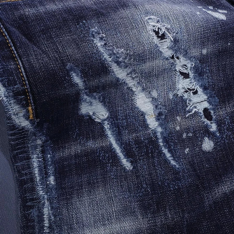 Close-up of distressed blue denim fabric with visible wear and tear.