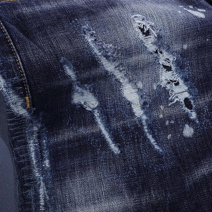 Close-up of distressed blue denim fabric with visible wear and tear.
