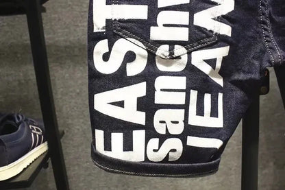 Close-up of a denim product with 'East West Jeans' branding on a stand.