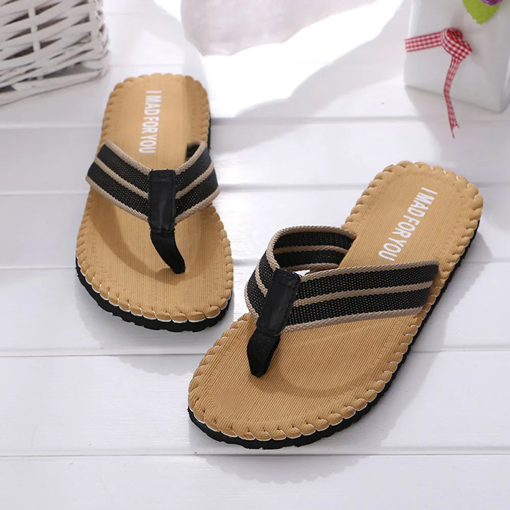 Pair of tan sandals with black straps on a white surface
