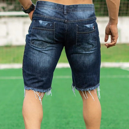 Person wearing blue denim shorts on a sports field