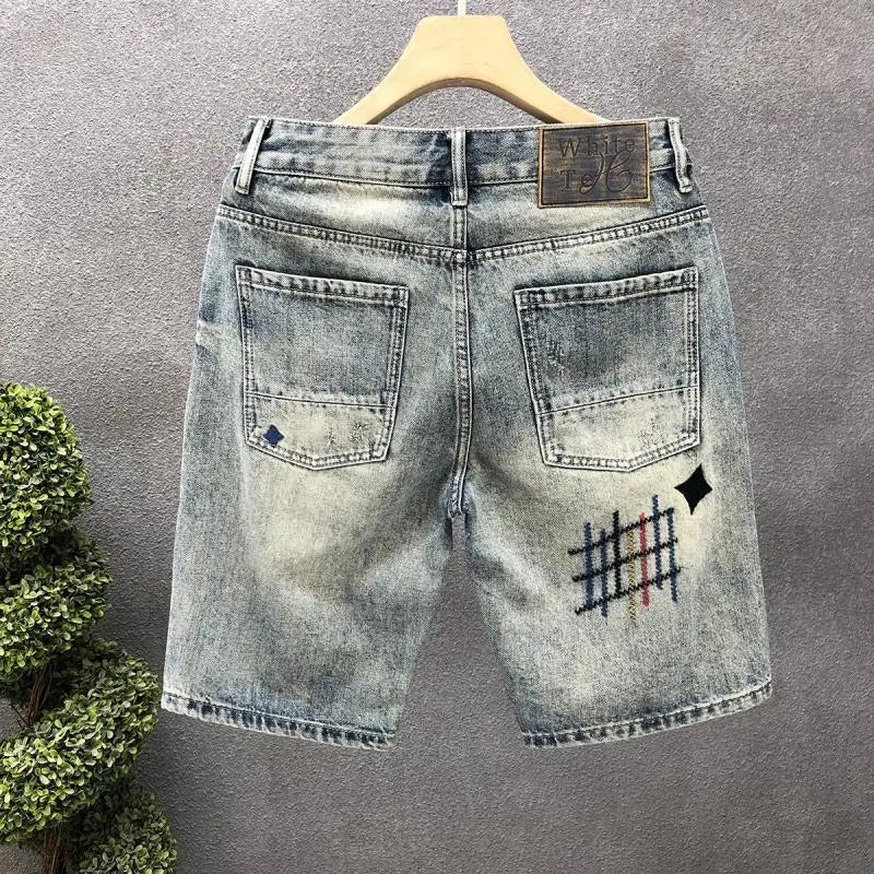 Blue denim shorts with a brand logo on a gray background