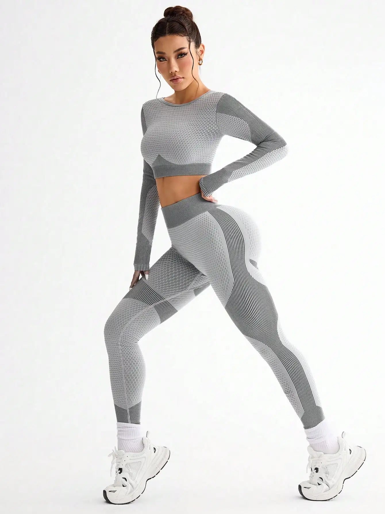 Woman wearing a gray athletic outfit on a white background