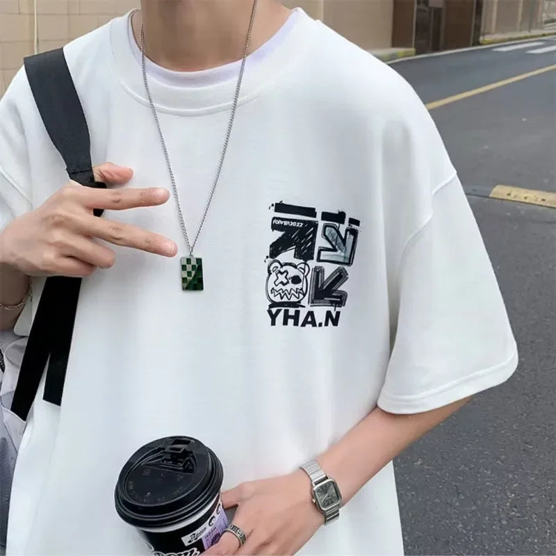 Person wearing a white t-shirt with black graphics and text, holding a coffee cup.