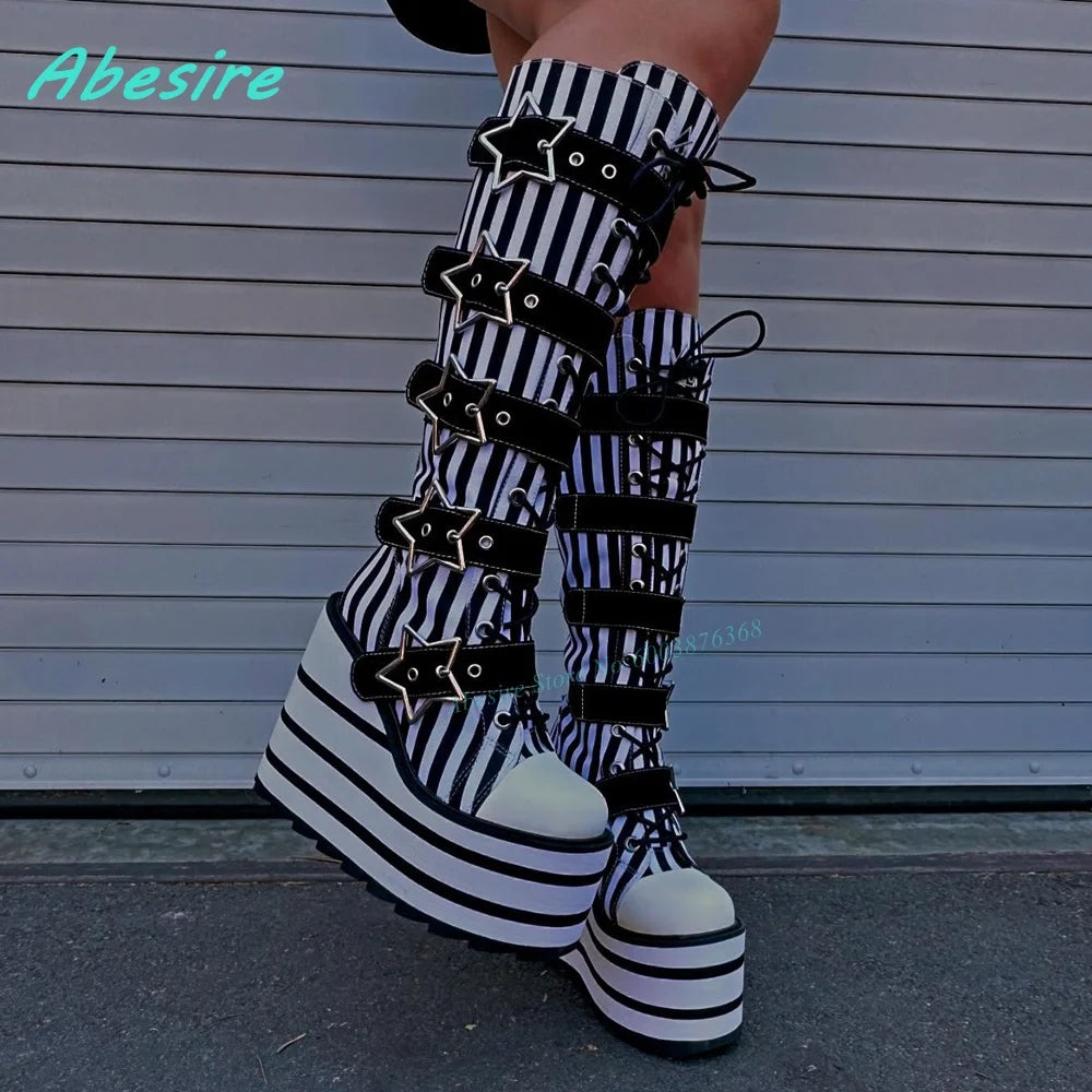 Black and white striped platform boots with star accents on a gray background