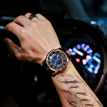 Hand wearing a luxurious watch with a tattoo on the arm, inside a vehicle.