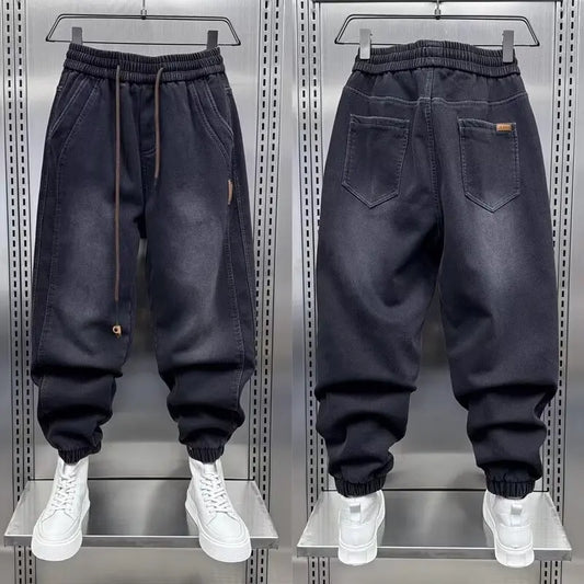Black jogger pants displayed on a metallic rack with white sneakers.