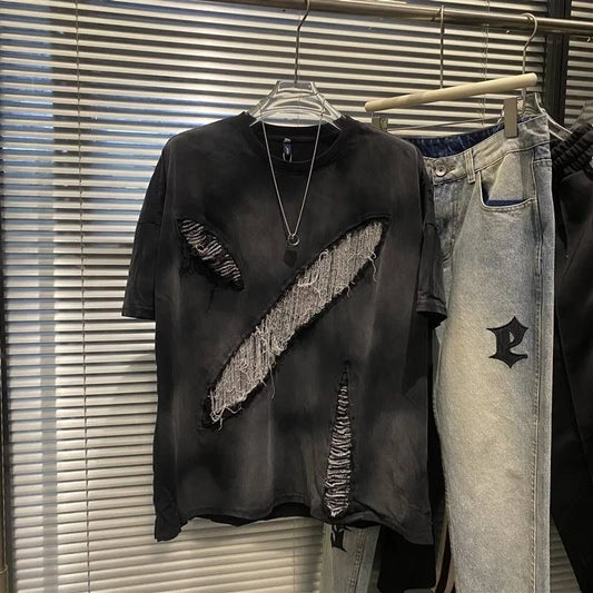Black distressed t-shirt and light blue jeans on hangers against a window with blinds.