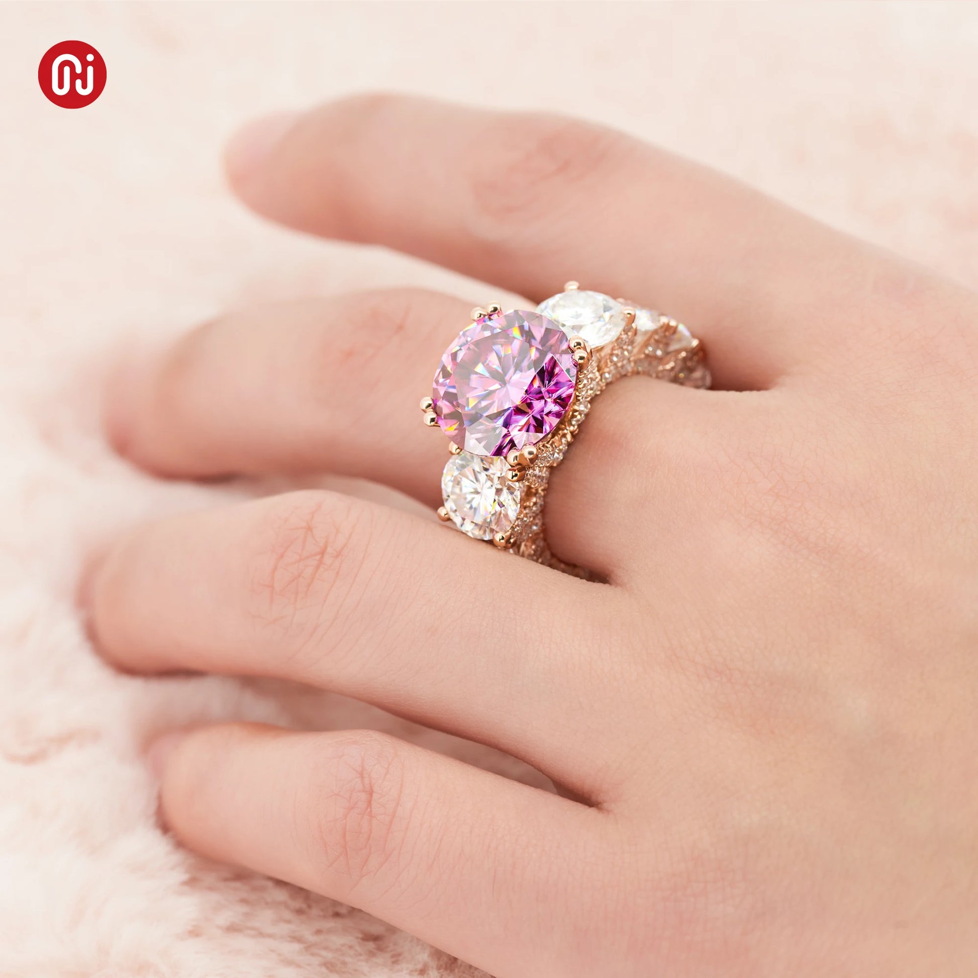 Ring with pink gemstone on a hand against a soft background