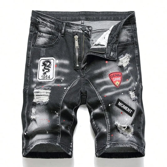 Black distressed denim shorts with patches on a white background