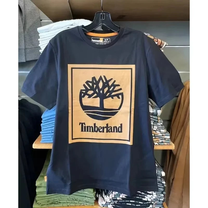 Navy blue t-shirt with Timberland logo on a hanger in a store setting