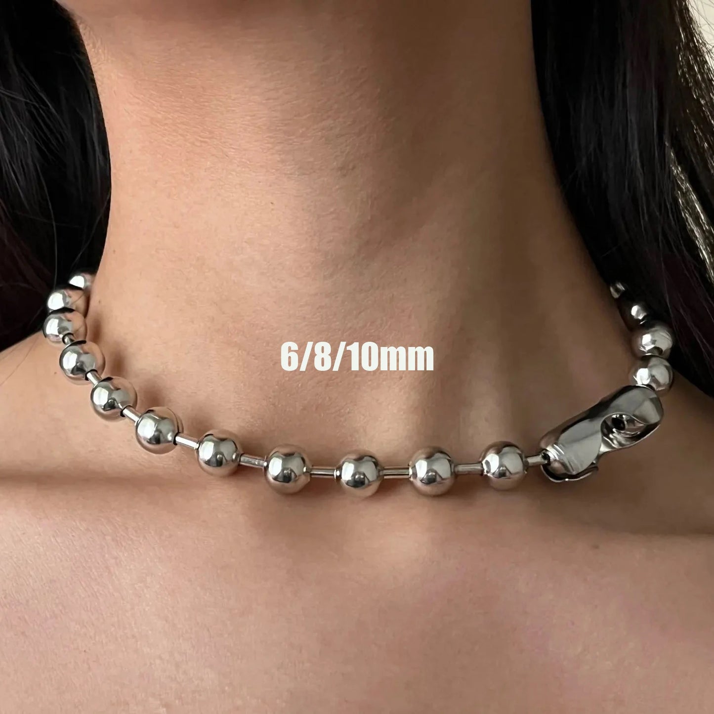 Silver beaded necklace on a person's neck with size labels '6/8/10mm'.