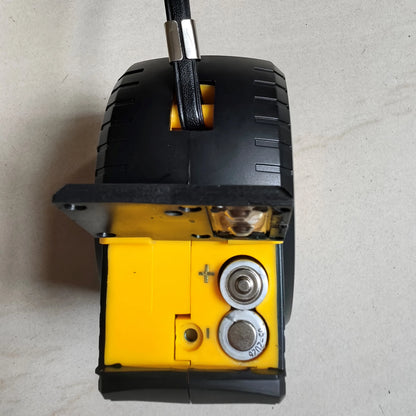 Close-up of a black and yellow mechanical component on a gray surface
