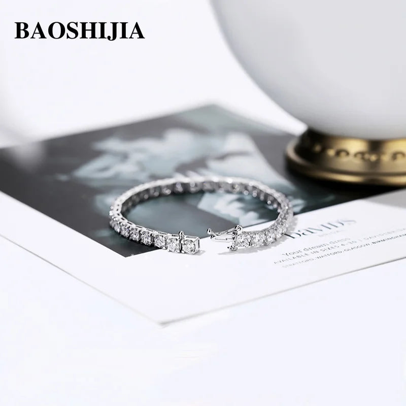 Silver ring with diamonds on a magazine with 'BAOSHIJIA' branding.