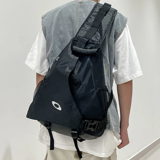 Person wearing a black sling bag over one shoulder against a plain background