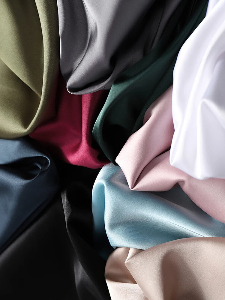 Close-up of various colors of fabric including green, red, pink, blue, and beige.