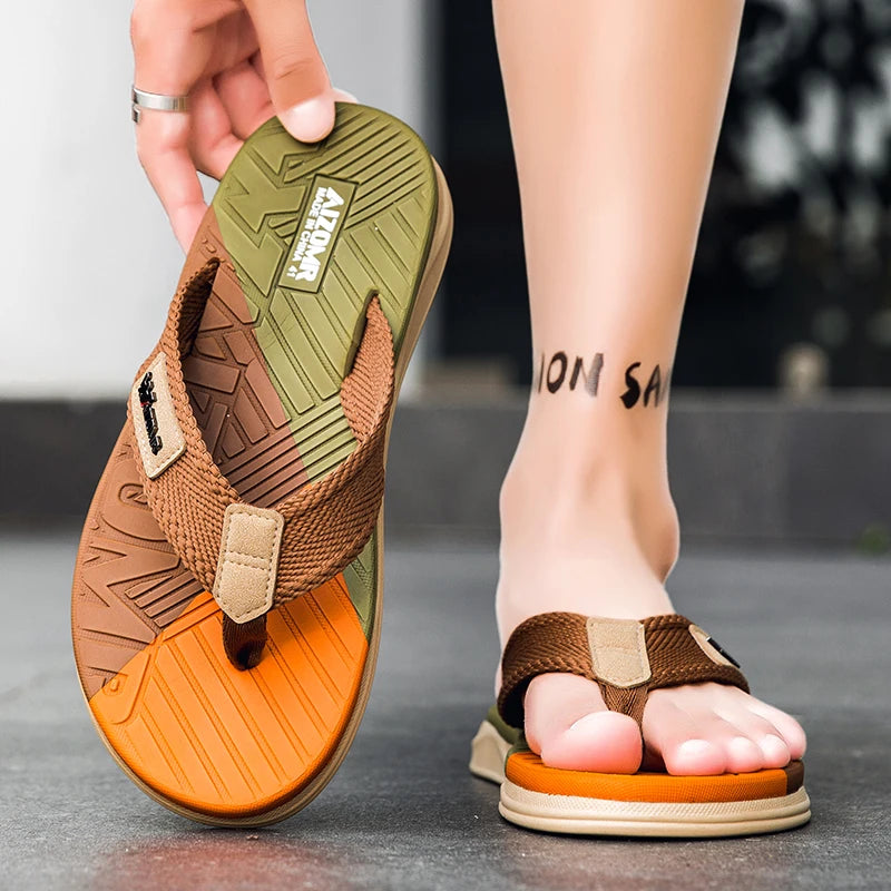 Brown and orange sandals with a brand logo, worn on feet.