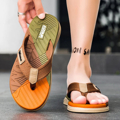 Brown and orange sandals with a brand logo, worn on feet.