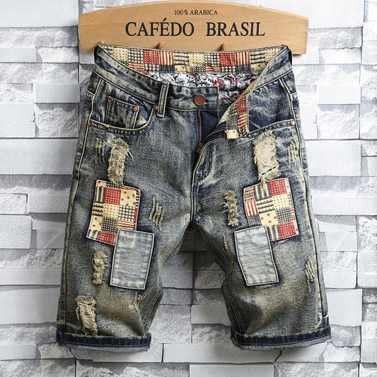 Distressed denim shorts with patchwork design on a stone wall background