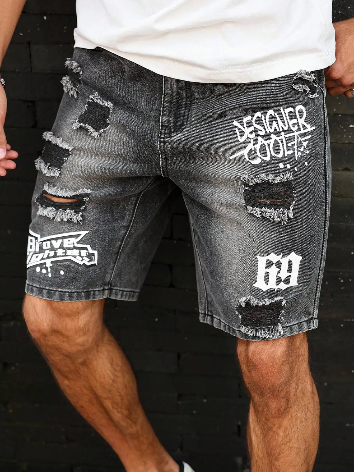 Distressed denim shorts with branding on a dark background