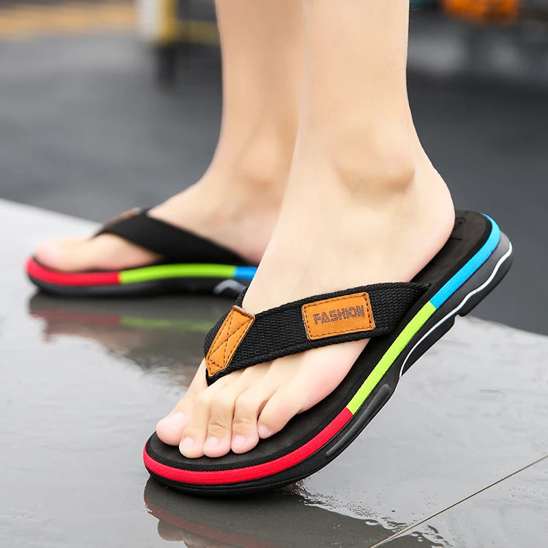 Black sandals with colorful straps worn on a reflective surface