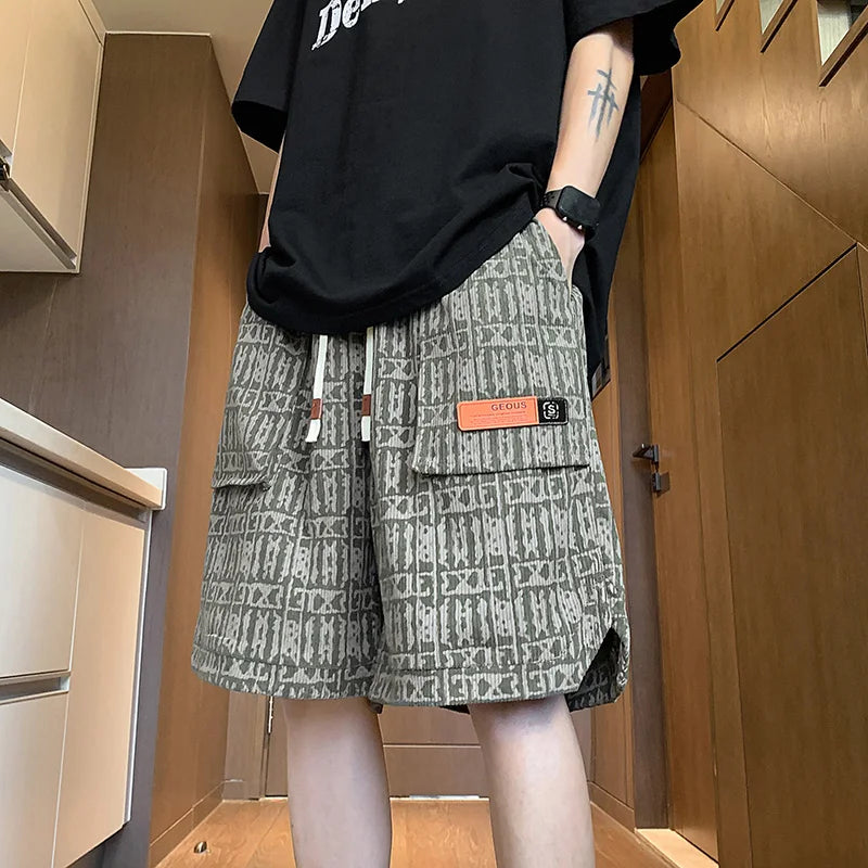 Person wearing a black oversized sweatshirt and patterned shorts in an indoor setting.