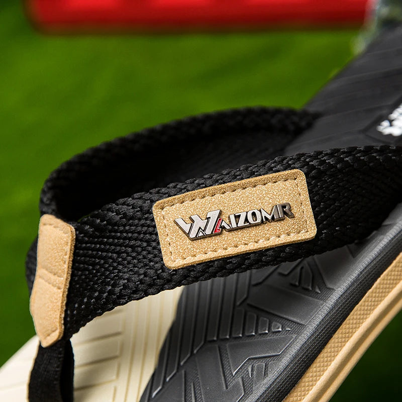 Close-up of a sandal strap with 'Wizomr' logo on a blurred green background