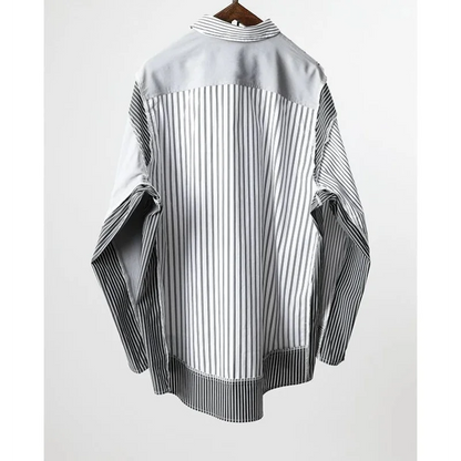 Black and white striped shirt on a hanger against a white background