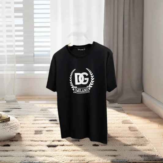 Black t-shirt with a logo on a hanger in a room with curtains and a rug.