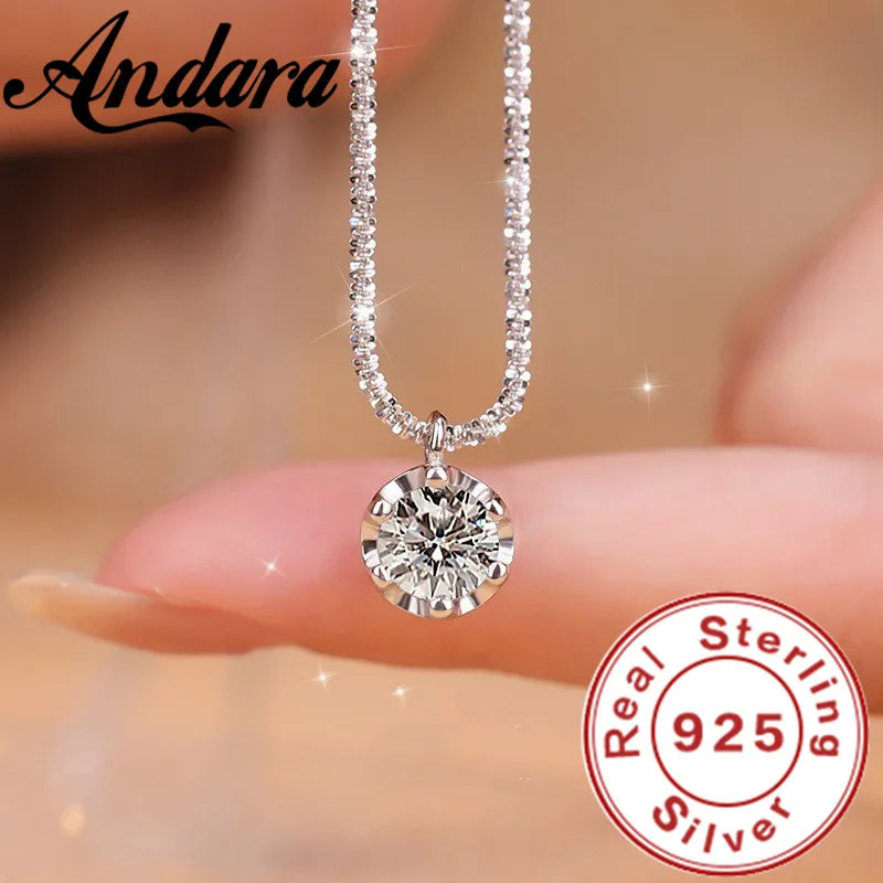 Silver necklace with a round pendant held by fingers, Andara brand visible, 'Real Sterling 925' stamp.